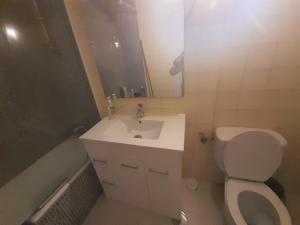 W łazience znajduje się umywalka, toaleta i lustro. w obiekcie Room in Guest room - Peaceful accommodation in Madrid near Atocha w Madrycie