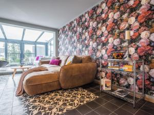 uma sala de estar com um sofá e uma parede floral em Luxus FeWo 112m² direkt am Wasser inkl. Boot em Krakow am See