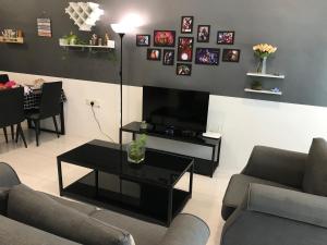 uma sala de estar com sofás, uma televisão e uma mesa em MAYA SeaView Families Suite Apartment + Sky Pool em Kuah