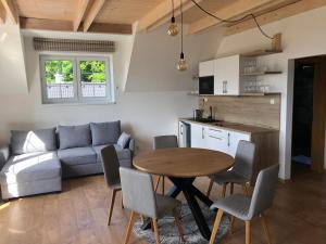 a kitchen and a living room with a table and chairs at Chalupa pod bukom in Predná Hora
