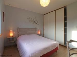 una camera con un letto bianco e due lampade di Gîte Juvigny-Val-d'Andaine, 5 pièces, 9 personnes - FR-1-497-115 a Saint-Denis-de-Villenette