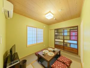 uma sala de estar com uma mesa e uma televisão em 宿家千の森 em Tóquio