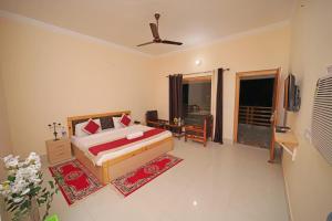 - une chambre avec un lit et une chambre avec un ventilateur dans l'établissement FabHotel Corbett Green View Garden and Stay, à Rāmnagar