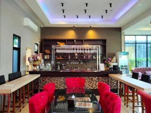un restaurante con sillas rojas y un bar en Pongsakorn Boutique Resort -SHA Extra Plus en Lat Krabang