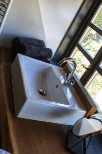 La salle de bains est pourvue d'un lavabo blanc et d'une fenêtre. dans l'établissement Schloss-Muehlen, à Horb am Neckar