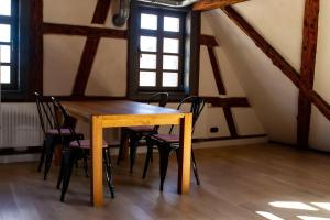 - une table et des chaises en bois dans une chambre avec fenêtres dans l'établissement Schloss-Muehlen, à Horb am Neckar