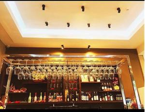 un bar con muchas copas en un estante en Pongsakorn Boutique Resort -SHA Extra Plus en Lat Krabang