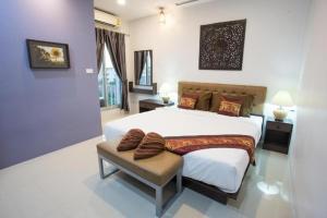 a bedroom with a large bed and a chair at Pongsakorn Boutique Resort in Lat Krabang