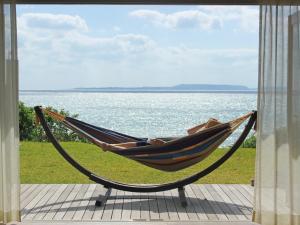 宜野座库库鲁度假屋的躺在吊床上俯瞰水面的人