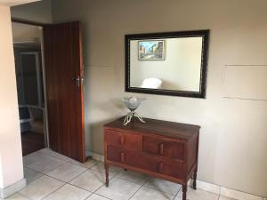 a room with a dresser and a mirror on a wall at Upstairs at the Miles’ in George