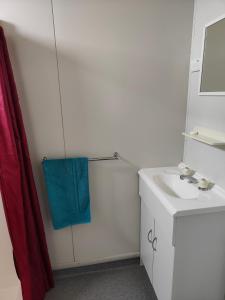 a bathroom with a sink and a blue towel at Airport Whyalla Motel in Whyalla +44 photos