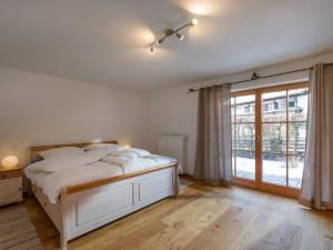 a bedroom with a bed and a large window at Ferienwohnung Bergahorn in Oberaudorf