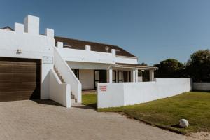 a white house with a garage in front of it at Craylord in Paternoster
