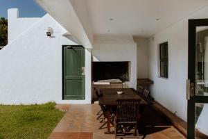 a patio with a table and a green door at Craylord in Paternoster