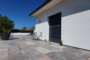 a white building with a black door and a patio at Studio Provence in Istres