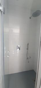Baño blanco con ducha con puerta de cristal en Studio Provence, en Istres