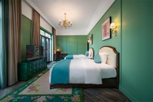 a bedroom with a large bed and green walls at Hotel Indigo Heilong Lake, an IHG Hotel in Meishan