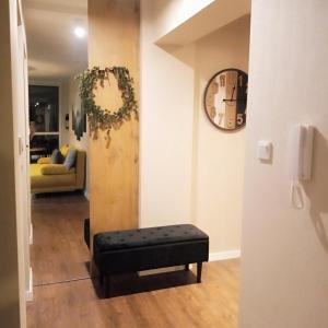 a living room with a bench and a clock on the wall at Apartament SPA 40 Resort Kozubnik blisko Szczyrk - 5D Apartamenty in Porąbka