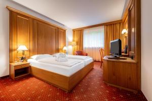ein Schlafzimmer mit großem Bett und Fernseher in der Unterkunft VILA VITA Burghotel Dinklage in Dinklage
