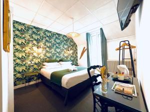ル・テュケ・パリ・プラージュにあるHôtel Gaspardのベッド、デスク、デスクが備わるホテルルームです。