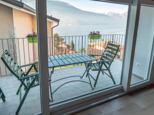 una mesa y sillas en un balcón con vistas al océano en Bellano Holidays - Casa Artemio en Bellano
