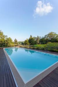 a large blue swimming pool with a wooden deck at Le Querce Hotel in Salsomaggiore Terme