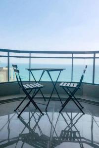 2 stoelen en een tafel op een balkon bij Royal Aparatment on the Sea , Blvd Nitza 34 in Netanya