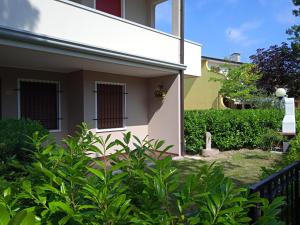 a white house with a plant at Adriella apartments in Bibione