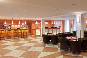 ゲストリング・アン・デア・イップスにあるJUFA Hotel Hochkarのテーブルと椅子のあるレストラン、キッチンが備わります。
