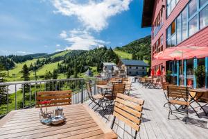 una terraza con mesas y sillas y un edificio en JUFA Hotel Hochkar en Göstling an der Ybbs