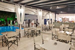 ネオス・マルマラスにあるAriadni Blueのテーブルと椅子のあるレストラン、プールを提供しています。