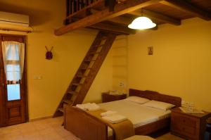 sypialnia z łóżkiem i drewnianą drabiną w obiekcie Ellinospito w mieście Axós