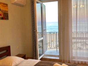 a bedroom with a large window with a view of the ocean at Hotel Golden Beach in Zatoka