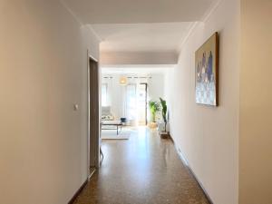 a hallway with white walls and wooden floors and a hallway with a hallway at Selva La Bella. En el Corazón de Triana in Seville