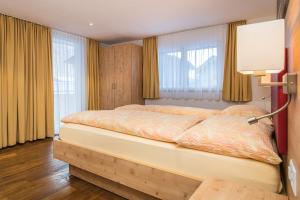 a bedroom with a large bed in a room with windows at Ferienhaus Matterhorngruss in Zermatt