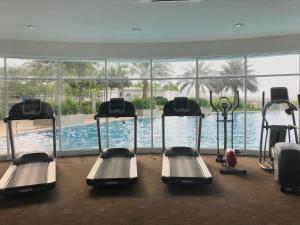 a gym with several treadmills and a swimming pool at Teduhan Kasih Homestay in Putrajaya