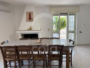 una sala da pranzo con tavolo e sedie di Villa Goa Beach a Torre Lapillo