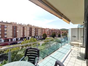 a balcony with chairs and a view of a city at Precioso apartamento 4 habitaciones con piscina y gym in Lloret de Mar