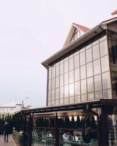 un edificio con gente sentada en mesas delante de él en Rivoli Hotel en Chernivtsi