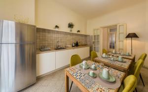 a kitchen with two tables and a refrigerator at BED and BIKE - BERGAMO Dream House in Bergamo