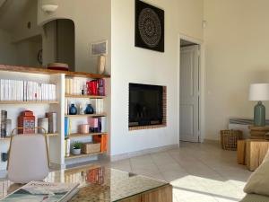 a living room with a fireplace and a glass table at Villa Bougainville in Porticcio