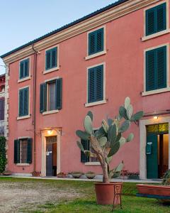 a pink building with a tree in front of it at B&B da Miriam in Castelnuovo del Garda