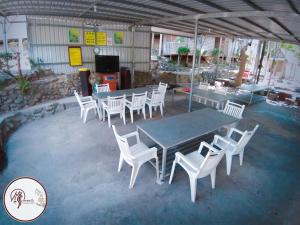 un grupo de sillas blancas y una mesa y algunas mesas y sillas en INUAN Hotspring Villa, en Taimali