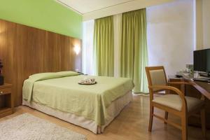 a bedroom with a bed and a desk and a chair at Leto Boutique Hotel Agrinio in Agrinio