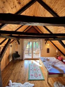 a attic room with a bed and a window at Country House Novosel in Duga Resa