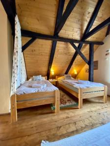 two beds in a room with wooden ceilings at Country House Novosel in Duga Resa