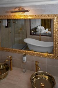 a bathroom with a sink and a tub in a mirror at Hotel Integra Banja Luka in Banja Luka