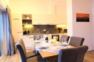 a dining room with a table and chairs and a kitchen at Appartements Cilli in Neukirchen am Großvenediger