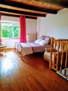 1 dormitorio con cama y cortina roja en Chez Jul, en Bulligny