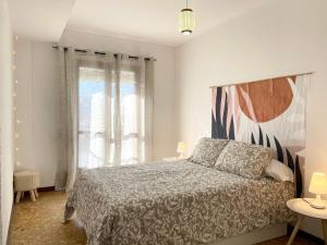 a bedroom with a bed and a large window at Selva La Bella. En el Corazón de Triana in Seville